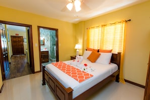 Relax in a stylish room with a large bed, nightstand, and ceiling fan.