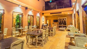 Un restaurante acogedor con mesas y sillas de madera, un balcón y una estantería.