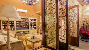 Una sala de estar acogedora con un sofá, una mesita de centro y una estantería llena de libros y objetos decorativos.