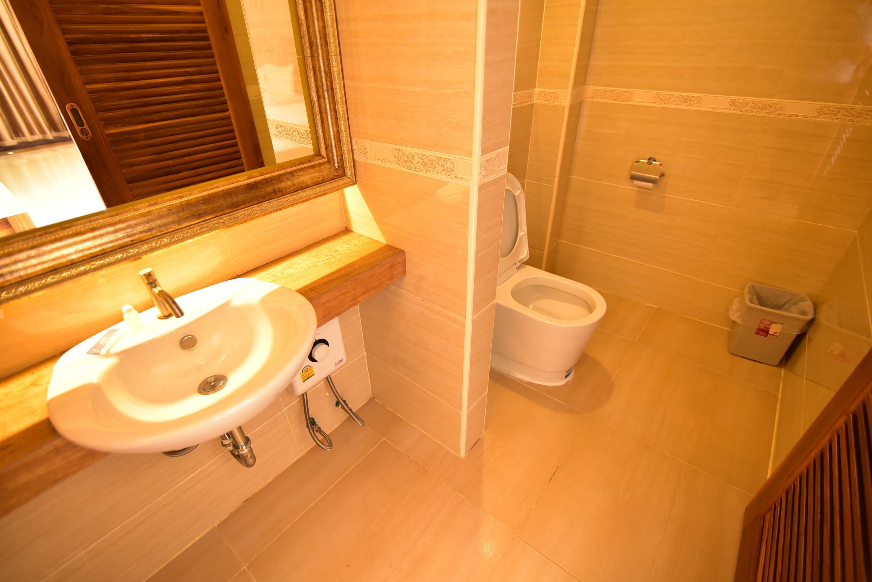 A bathroom with a sink, toilet, and a mirror.