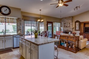 Enjoy a warm meal in the kitchen with a central island, dining area, and cozy seating area with a fireplace.