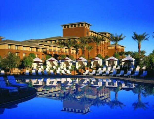Relax by the pool surrounded by lounge chairs and umbrellas.