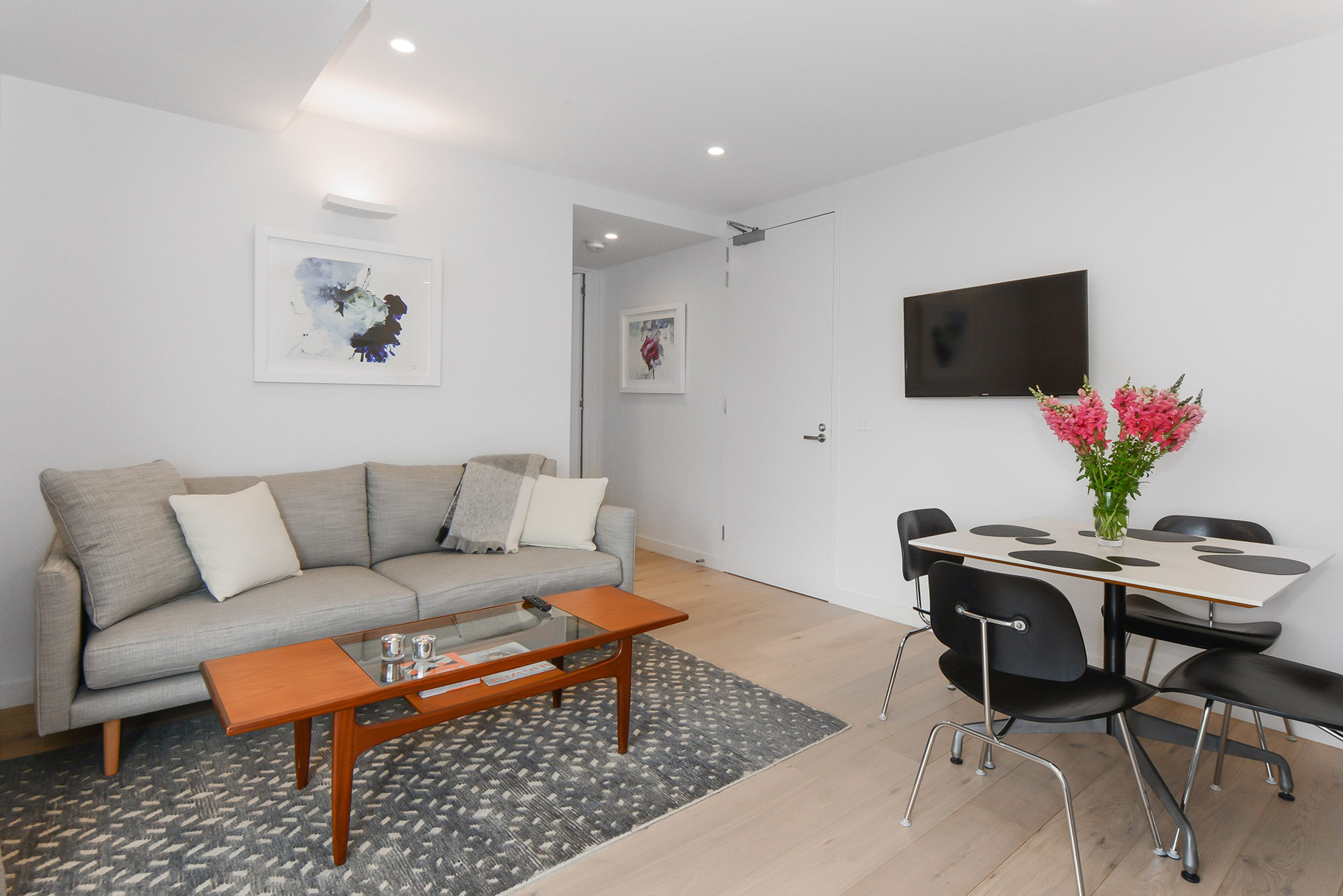 Un salon moderne comprenant un canapé, une table basse et un coin repas avec des chaises et une table.