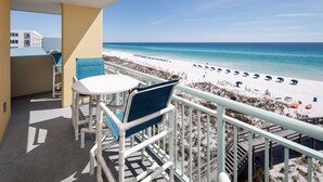 A balcony with a view of a beach, a table, and chairs. - PI 501: Flip Flop Flats - Spectacular East 5th Floor Corner Unit Memory Maker (Fort Walton Beach)