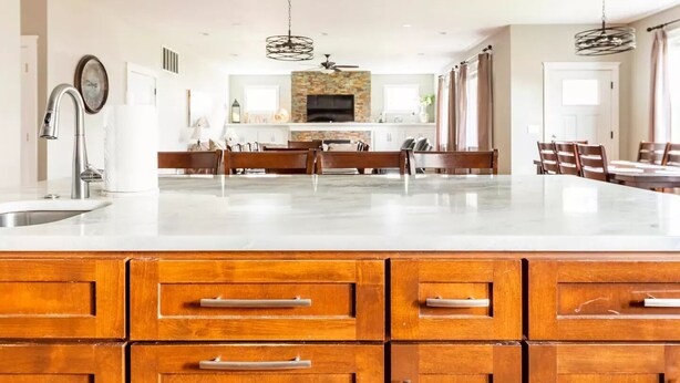 Una cocina amplia con una isla grande, armarios de madera y salpicadero de piedra.