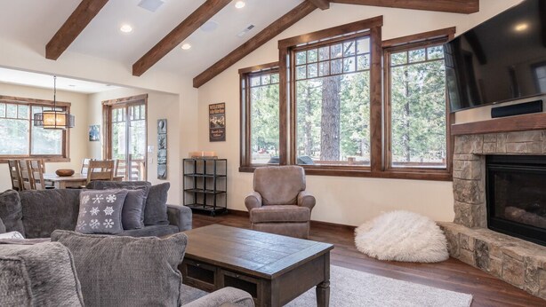 A spacious living room with a fireplace, large windows, and a cozy seating area. - Luxury Cabin with Private Hot Tub! Close to Village! (Mammoth Lakes)