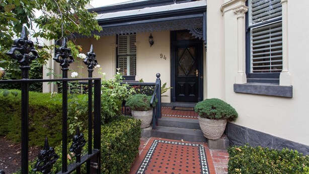 A house with a black door, white walls, and a small front garden with potted plants. - 94 Highett - Luxury 5 bedroom, 3 bathroom, 3 car park House in the Inner City (Richmond)