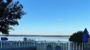 A swimming pool with a view of a lake and a white picket fence. - Modern 300 ft lakefront with pool (Mayville)