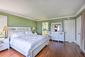Un dormitorio con cama, mesitas de noche, cómoda y espejo.