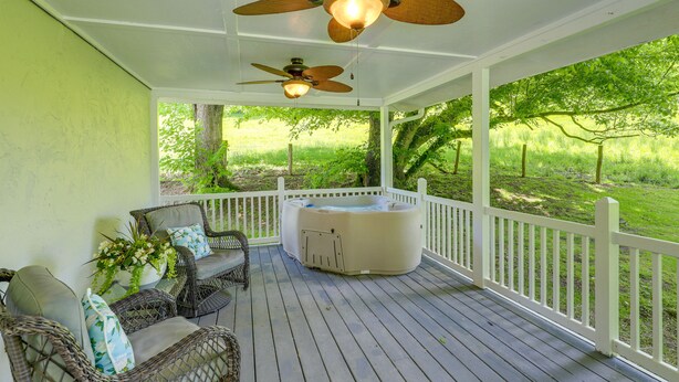 A covered porch with wicker furniture, a hot tub, and a ceiling fan. - Best Getaway for 2 w/ Own Creek & Hot Tub (Marshall)
