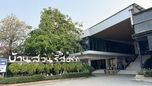 A modern building with a large sign in a foreign script, a staircase leading to the entrance, and a well-maintained garden area. - Bansuan Resort (Nakhon Sawan)