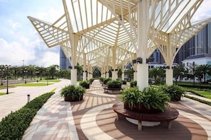 A covered outdoor area with a geometric roof structure, potted plants, and a curved pathway. - Wow! Homes by Christine - Vinhomes Luxury (Ho Chi Minh City)
