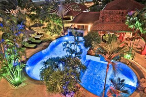 Una piscina al aire libre, sombrillas, sillones reclinables de piscina