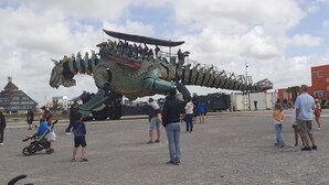 A large dragon sculpture with people on top, a building labeled "RESTO BAR" in the background, and a port facility. - STUDIO Appart gite Petite Halte,... work, vacation. (Wavrans sur l'aa)