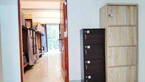 A hallway with a wooden wardrobe and a black filing cabinet. - Ninety 9 Hostel (Bangkok)