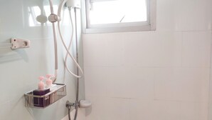 A small, clean bathroom with a shower, a window, and a soap dispenser on the wall. - Ninety 9 Hostel (Bangkok)