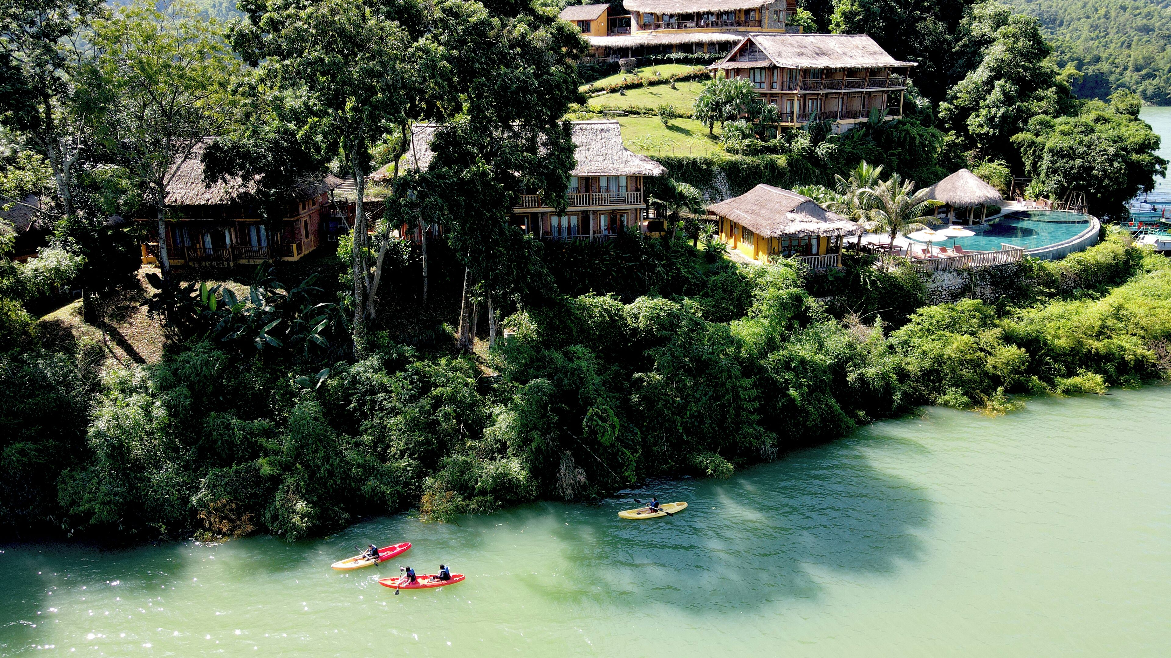 Un resort con diversi edifici, una piscina e un fiume dove si possono praticare kayak.