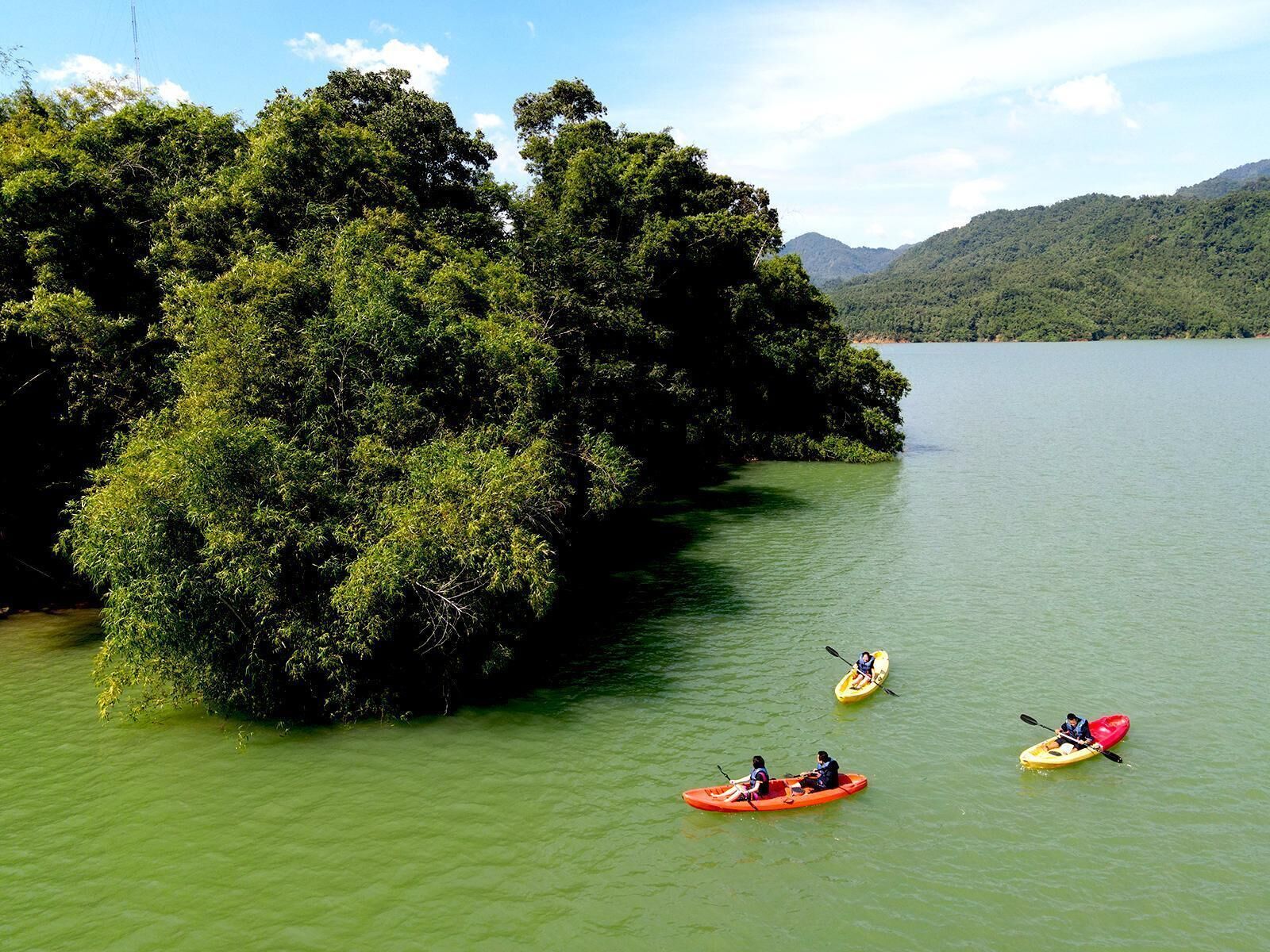 A calm lake surrounded by dense forest and hills.