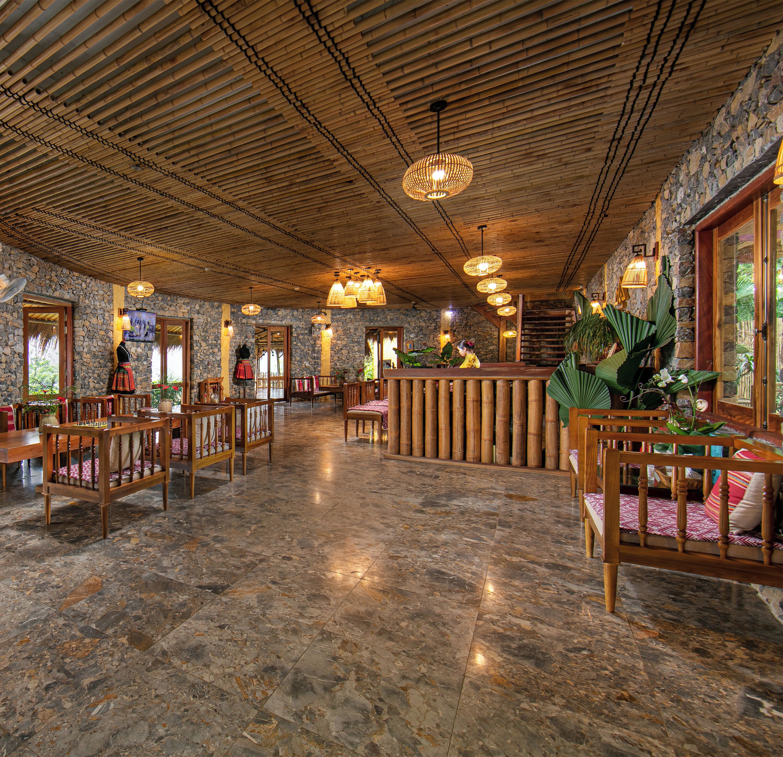 A spacious lobby with a high ceiling, stone walls, and a central reception area.