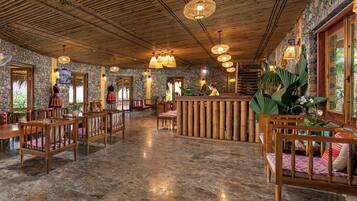 A spacious lobby with a high ceiling, stone walls, and a central reception area.