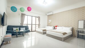 A modern hotel room with a sofa, two beds, a desk, and a TV. - Goodfriend B&B (Magong)