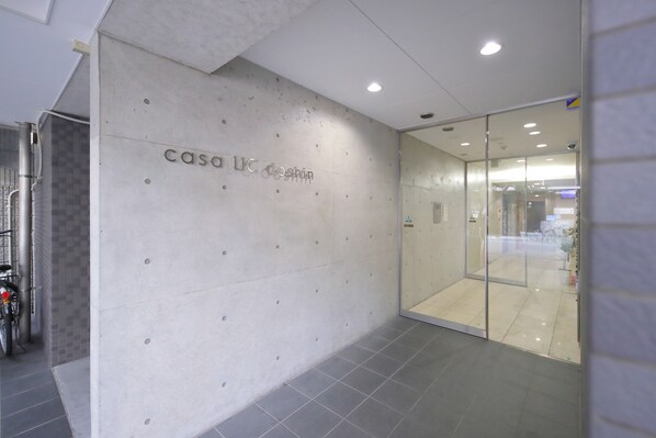 A modern interior with a concrete wall displaying the text "CASO 11C" and a glass door leading to another room.