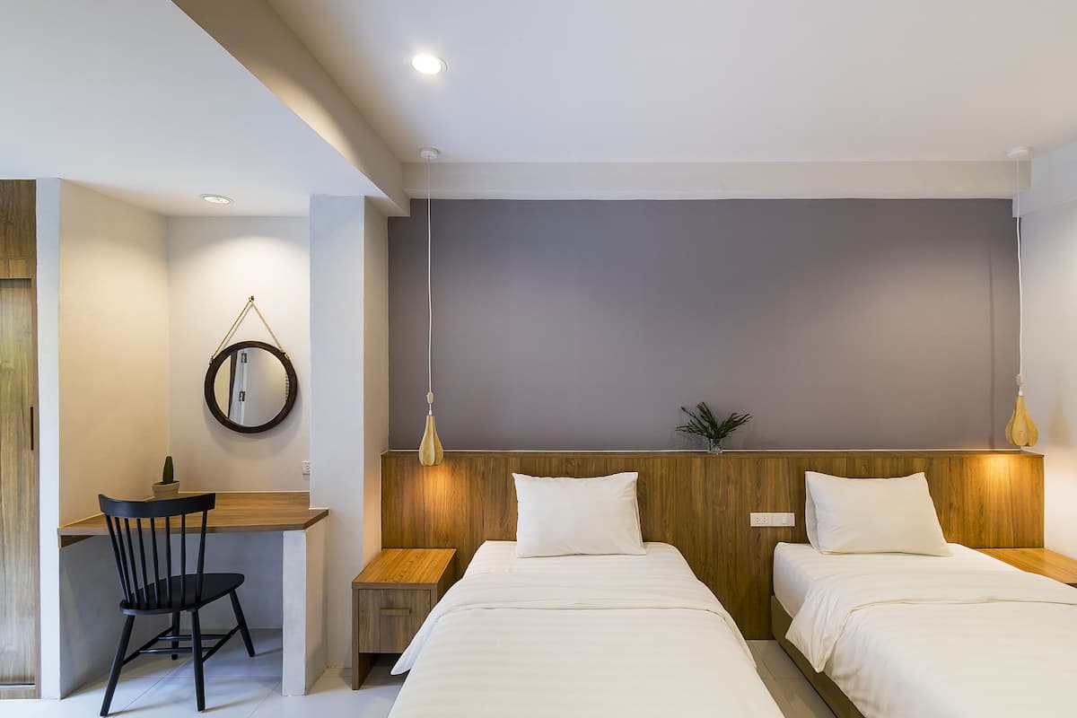 Una habitación de hotel moderna con dos camas, un escritorio y una silla.