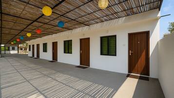 Un pasillo cubierto con múltiples puertas y ventanas que conduce a habitaciones individuales.