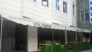 A hotel named "OTEL TÜRKER" with a covered outdoor seating area and a visible entrance. - Otel Turker (Sile)