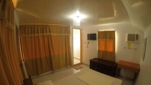 A bedroom with a bed, a desk, a TV, and curtains. - Buena Lynne's Resort Annex (Puerto Galera)