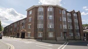 A multi-story brick building with a corner entrance, large windows, and a flat roof. - Toast Lettings | Milbungate View - Durham City (Durham)