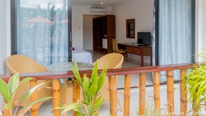 A balcony with wicker furniture, a table, and potted plants. - Alona Vida Beach Hill (Panglao)
