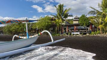 On the beach, black sand, sun loungers, beach towels