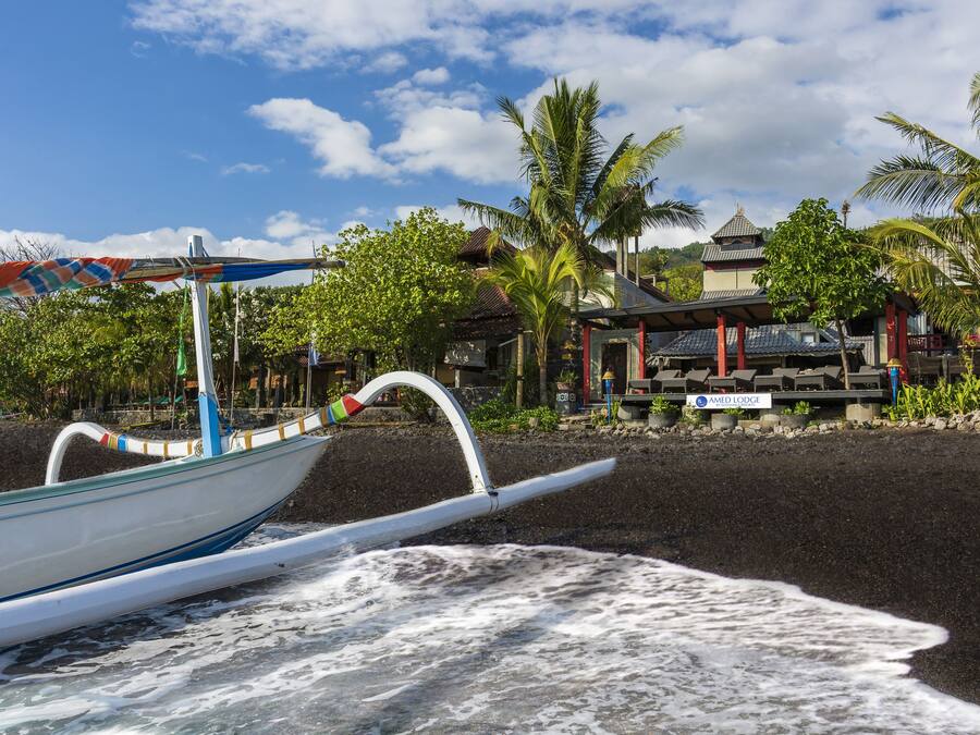 Am Strand, schwarzer Sandstrand, Liegestühle, Strandtücher