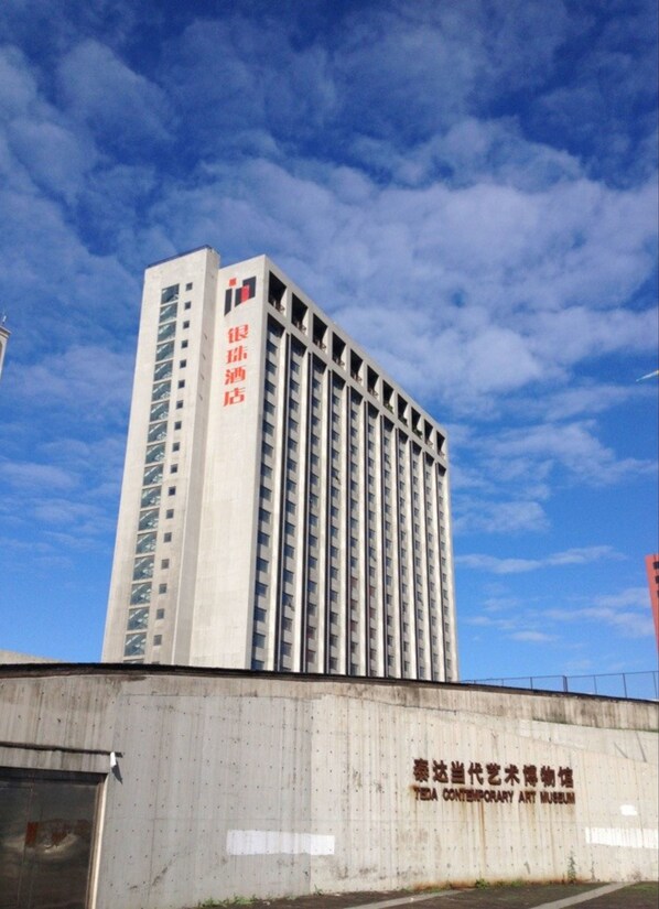 Un immeuble moderne et imposant, sur lequel on peut lire une enseigne en caractères chinois.