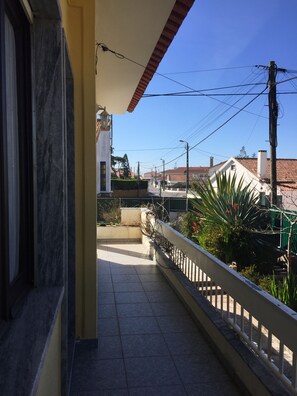 Enjoy the view from this balcony overlooking a charming residential street.