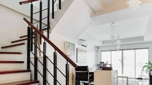 Een modern interieur met een houten trap, een bureau en een groot raam.