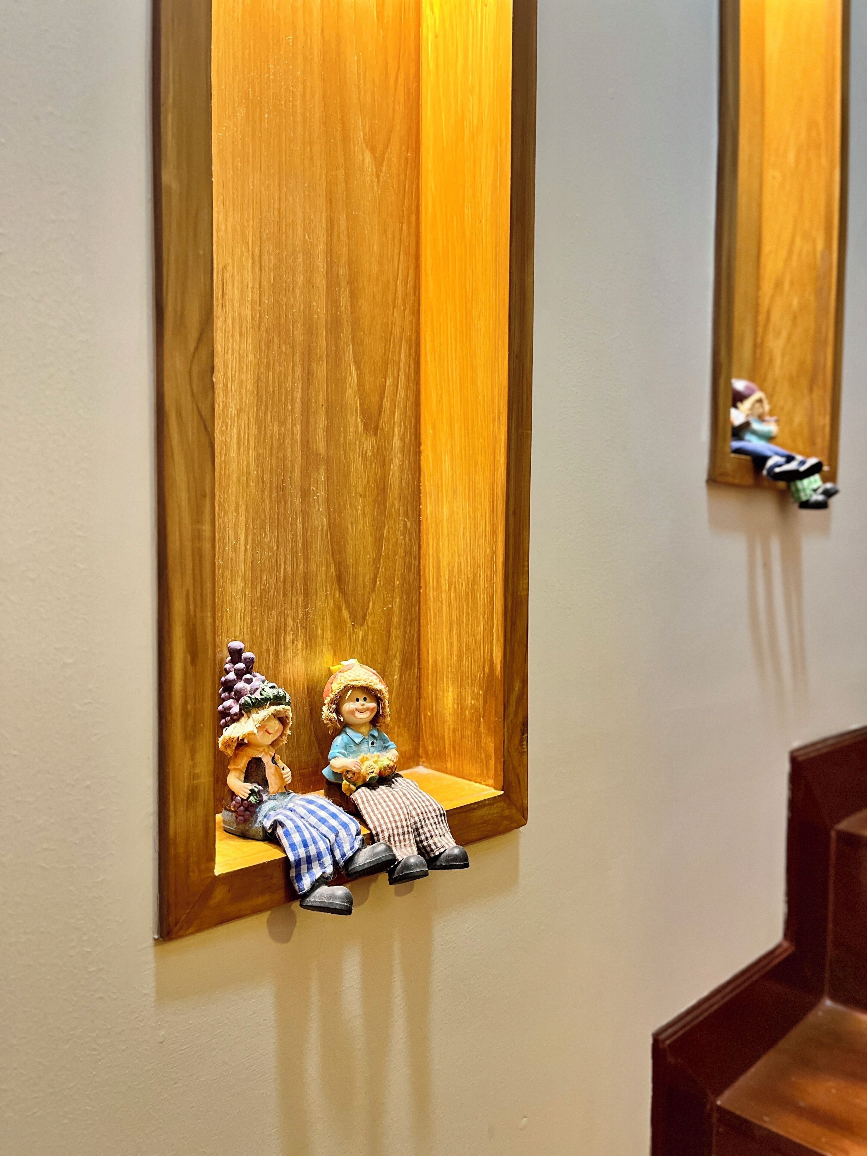 A wooden shelf with two figurines.
