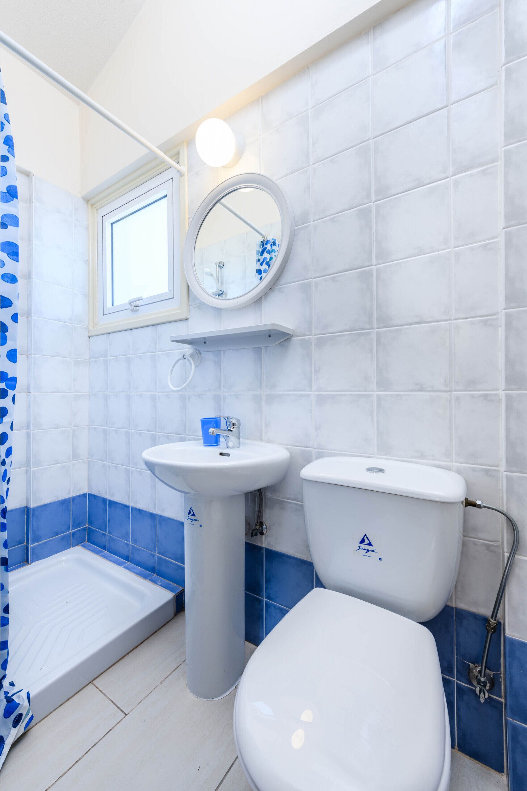 A bathroom with a white sink, a toilet, and a shower area.