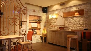 Eine gemütliche Küche mit Steinwand, Holzbalken und einem Modell eines Segelbootes.