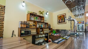 Un espace bar avec des étagères remplies de bouteilles d’alcool, de verres et une tireuse à bière.