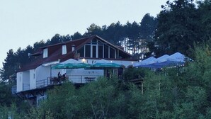 Un bâtiment à deux étages doté d’un balcon et d’un espace extérieur aménagé pour s’asseoir.