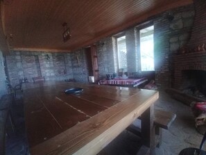 Ein rustikales Interieur mit einem Holztisch, Steinwänden und einem Kamin.