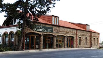 A brick building with a sign for 'Kanudos Restaurant, Winery, Guest House.'
