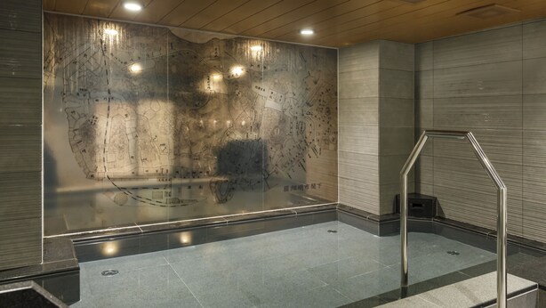 A modern indoor space with a large reflective wall, a metal staircase, and a tiled floor. - JR WEST GROUP VIA INN SHIMONOSEKI (Shimonoseki)