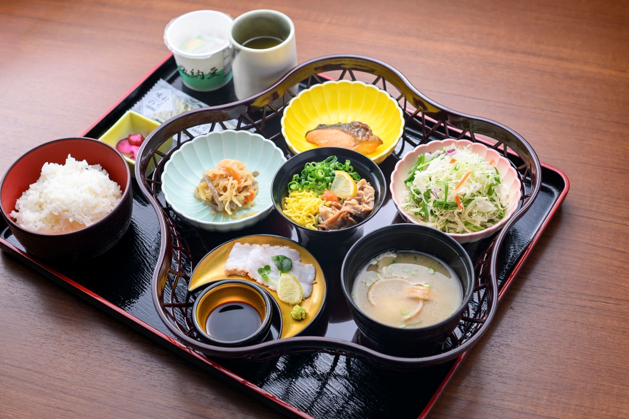 A tray with various dishes including rice, noodles, and soup.