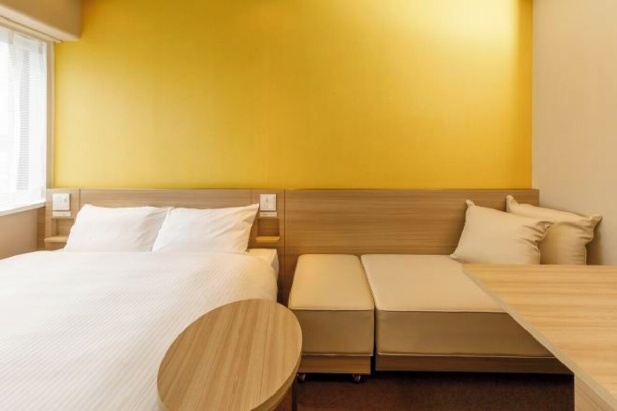 Ett hotellrum med en säng, en soffa och ett litet bord.