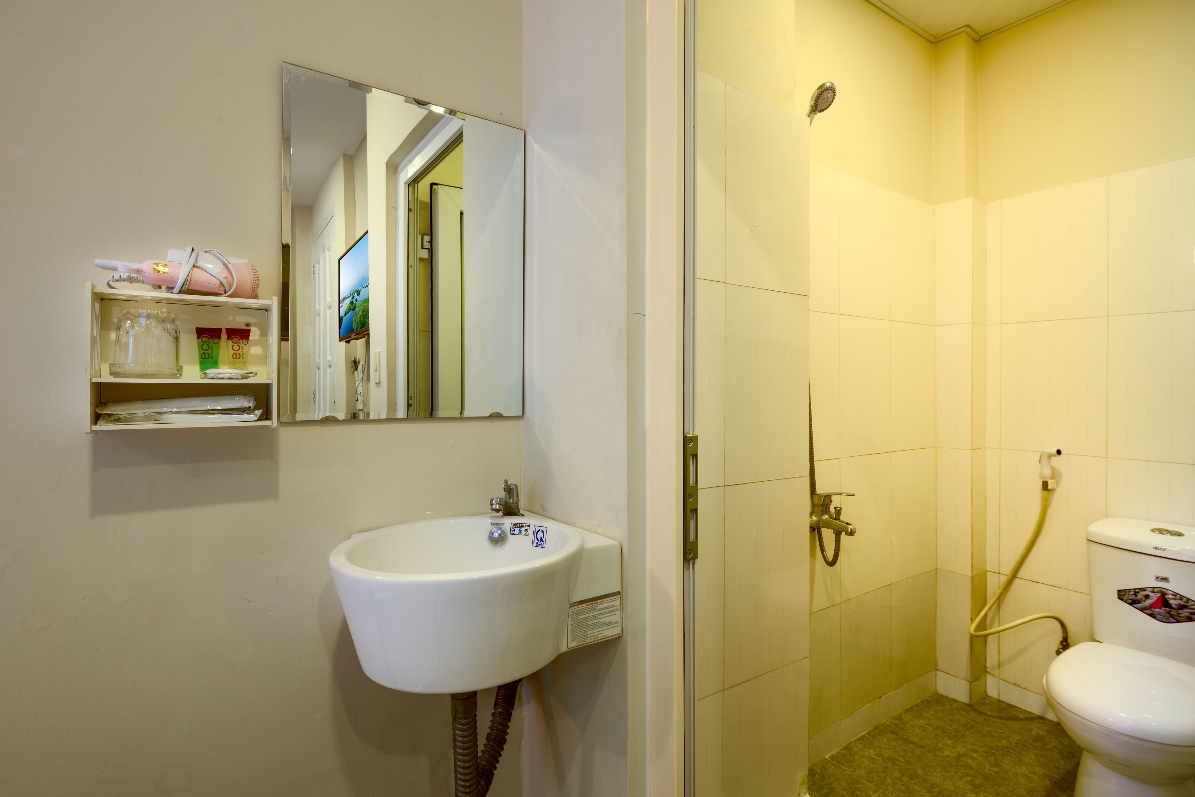 Une salle de bain avec un lavabo, un miroir et des toilettes.