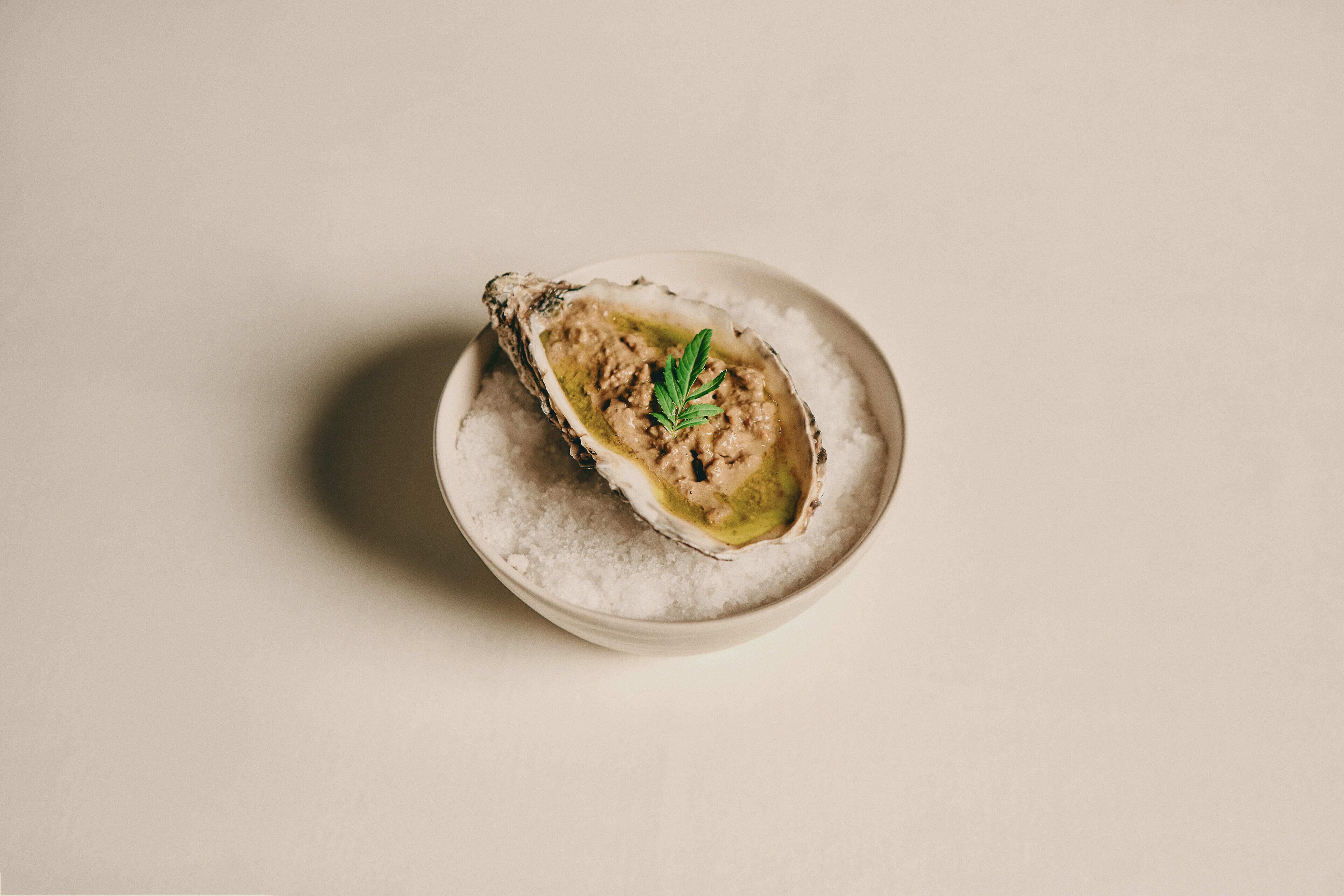 A single oyster on a bed of salt.