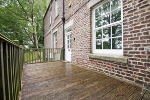 A brick building with a wooden deck and a window.